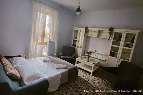 佛罗伦萨L'Oasi del Cervo的一间卧室配有一张床、一张沙发和一把椅子