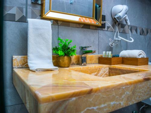 普埃布拉HOTEL MARGARITA的一间带大理石水槽和镜子的浴室