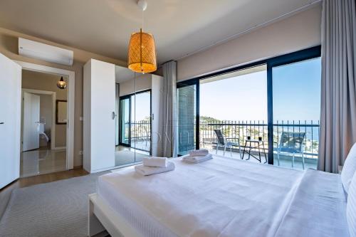 亚力卡瓦克Bovilla Hotel Yalıkavak的卧室设有一张大白色的床和大窗户