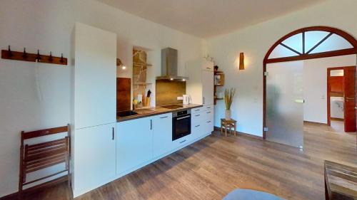 巴贝Las Fincas Baabe的一间铺有木地板的大厨房,配有白色的橱柜