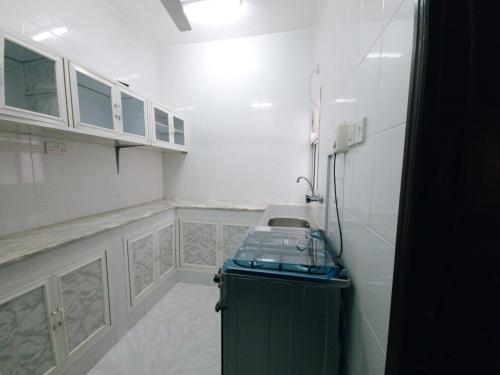 塞拉莱أجاويد Ajaweed的厨房拥有白色的墙壁和绿色的橱柜
