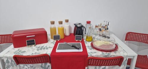 韦尔瓦Huelva Art的桌子上摆放着红色桌布,上面摆放着果汁