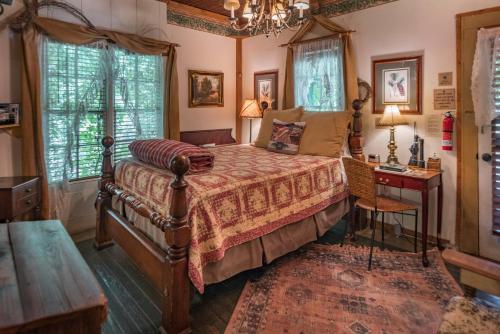 格伦罗斯Country Woods Inn的卧室配有床、桌子和窗户。