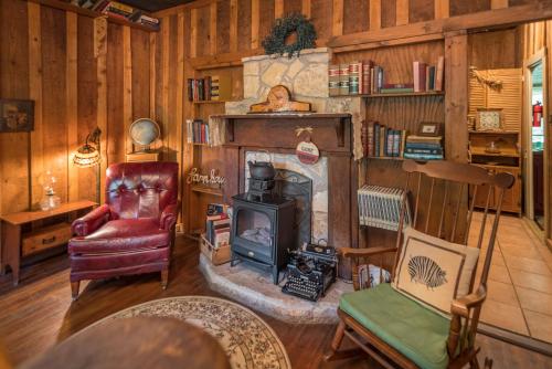 格伦罗斯Country Woods Inn的客厅设有壁炉和椅子