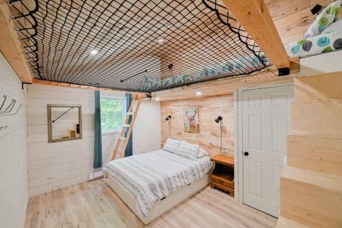 MansonvilleChalet Memphrémagog (Spa, étang, golf)的一间位于小房子的卧室,配有一张床和梯子