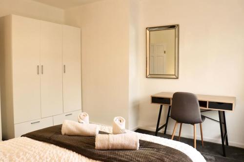 BeestonCharming 3 Bedroom Property FREE WiFi & Parking的一间卧室配有一张带书桌和镜子的床