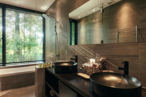 轻井泽La Maison Karuizawa的浴室配有2个盥洗盆和1个浴缸。