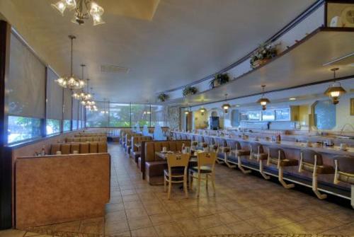 贝克斯菲尔德Duniya Hotel的餐厅内带桌椅的用餐室