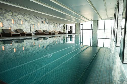 西安西安海荣JW万豪酒店的一个带椅子的游泳池以及一个游泳池