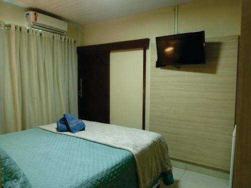 费尔南多 - 迪诺罗尼亚Pousada Marlin Azul的一间卧室配有一张床和一台平面电视