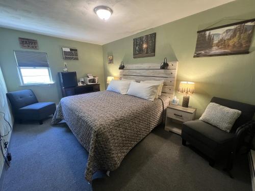圣伊尼亚斯Cedars Motel的一间卧室配有一张床和一把椅子