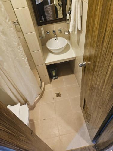 马尼拉Pacific Bay Grand Suites的一间带水槽和卫生间的小浴室