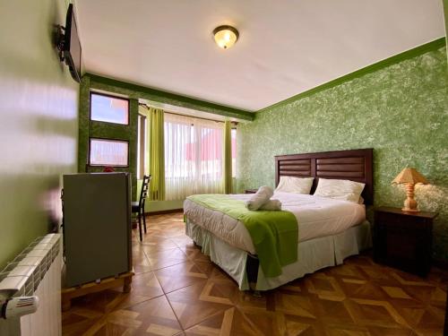 乌尤尼拉斯索拉斯酒店的一间卧室配有一张带绿色墙壁的床
