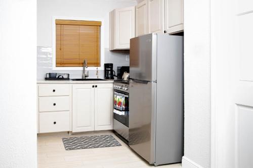 乔治镇Sheer Bliss BeachView Apt #1的厨房配有不锈钢冰箱和白色橱柜