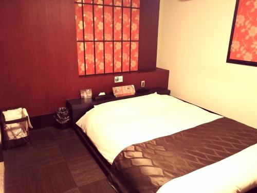 东京HOTEL WILL渋谷 LOVE HOTEL -Adult only-的一间卧室设有两张床,其中设有窗户。