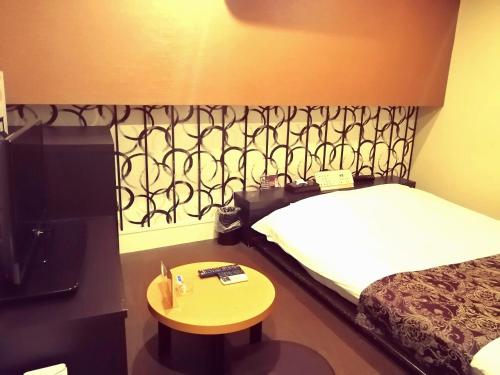 东京HOTEL WILL渋谷 LOVE HOTEL -Adult only-的酒店客房设有一张床和一张小桌子。
