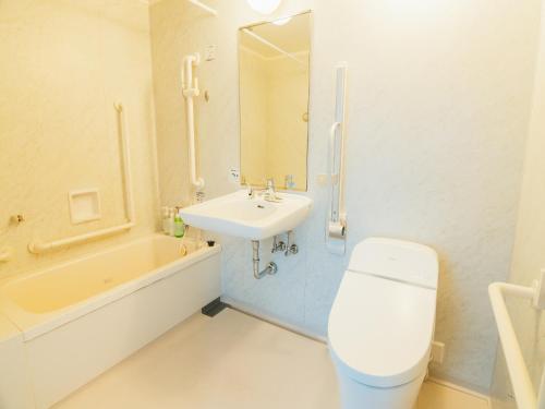 北九州Quintessa Hotel Kokura Comic & Books的浴室配有盥洗盆、卫生间和浴缸。