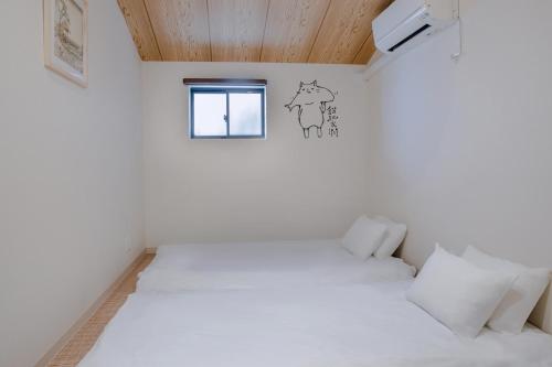 大阪桜の宿的卧室配有白色的床和窗户。