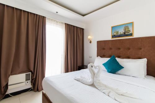 马尼拉Pacific Bay Grand Suites的酒店客房设有床和窗户。