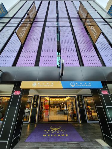 中坜宾利酒店的一座紫色外墙建筑的前方商店