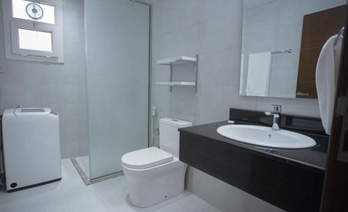 塞拉莱Anisa Residential Complex的白色的浴室设有水槽和卫生间。