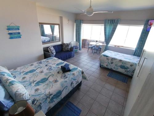 阿曼济姆托蒂Seaview Self Catering Amanzimtoti的一间卧室配有一张床,另一间卧室配有沙发。
