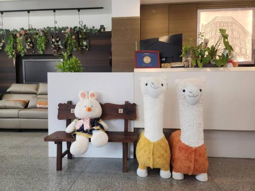 罗东镇家家商務旅館 Jia-Jia Business Hotel的两个塞满了东西的动物坐在一个房间里长凳上