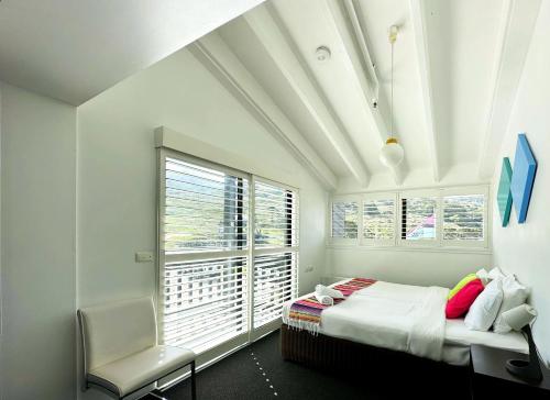 Charlotte PassStillwell Hotel的卧室配有床、椅子和窗户。