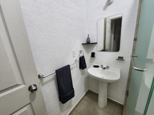 坎昆Hermosa Casa en Jardines Cancún的白色的浴室设有水槽和镜子