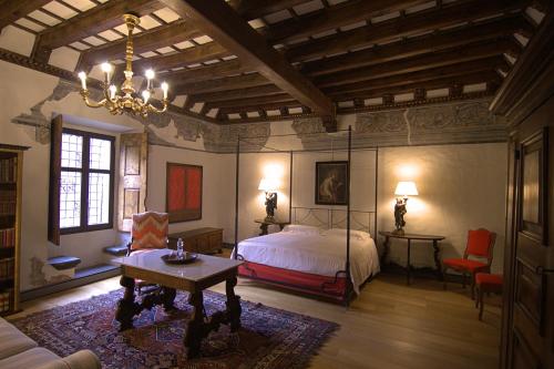 泰廖Palazzo Juvalta的一间卧室配有一张床、一张桌子和一个吊灯。
