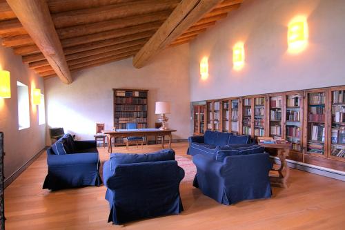 泰廖Palazzo Juvalta的图书馆配有蓝色的椅子、桌子和书籍