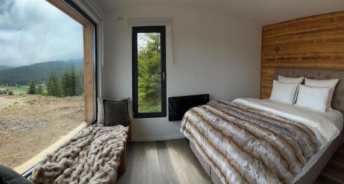 陶比斯特拉Heaven`s cabins的一间卧室设有一张大床和一个大窗户