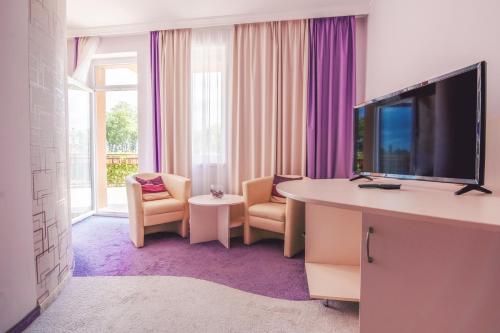 凯奇凯梅特格拉纳达会议、康体和体育酒店的酒店客房配有带电视和椅子的书桌