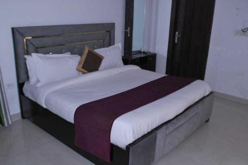 TājganjOYO Flagship 81442 Grey House Home Stay的卧室配有一张带白色床单和枕头的大床。