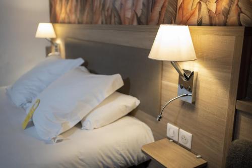 巴伯雷圣叙尔皮斯特鲁瓦机场诺富特酒店的酒店的客房 - 带一张带台灯和枕头的床