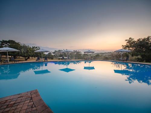 雾观Nkambeni Safari Camp的一座享有日落美景的大型游泳池