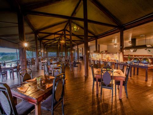 雾观Nkambeni Safari Camp的一间设有木桌和椅子的餐厅