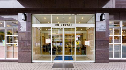 东京Toyoko Inn Tokyo Haneda Airport No.1的大楼前方装有玻璃门的商店