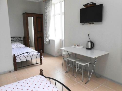 加格拉Guest House Gorny Ruchei的客房设有两张床、一张桌子和电视。
