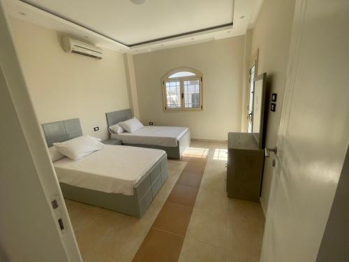 赫尔格达Moubark 6 Villa 1的一间卧室设有两张床和窗户。