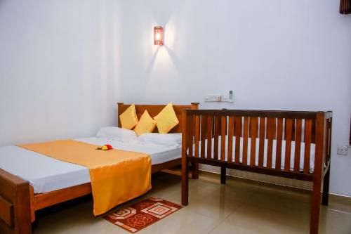 米瑞莎兰吉斯游客旅馆的一间设有两张床和一张婴儿床的房间
