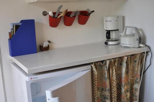 瑞伊Guesthouse Højland的厨房柜台配有咖啡壶和墙上的杯子