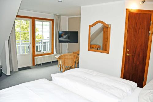 洛默Hotel Inselglück的一间卧室配有一张床、镜子和一张桌子