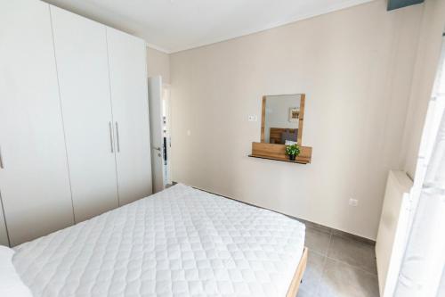 塞萨洛尼基Stylish Urban Getaway by thesbnb的白色卧室配有床和镜子