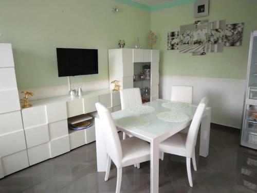 诺托玛丽娜Casa Falconara的白色的用餐室配有白色的桌椅