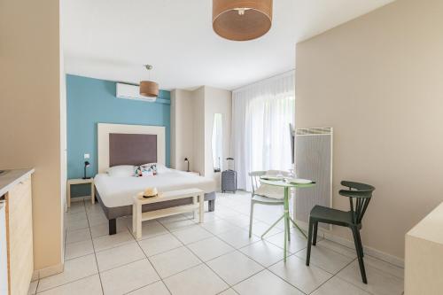 圣让迪拉克Appart'City Classic Bordeaux Aéroport St Jean D'Illac的卧室配有一张床和一张桌子及椅子