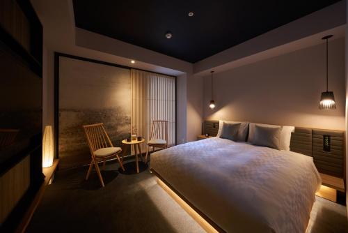 大阪Hotel Resol Trinity Osaka的一间卧室配有一张大床和一张桌子及椅子