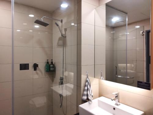 云顶高原TopGenting RedMarbleColdSty2R2B7Pax at GrdIonDelmn的浴室配有盥洗盆和带镜子的淋浴
