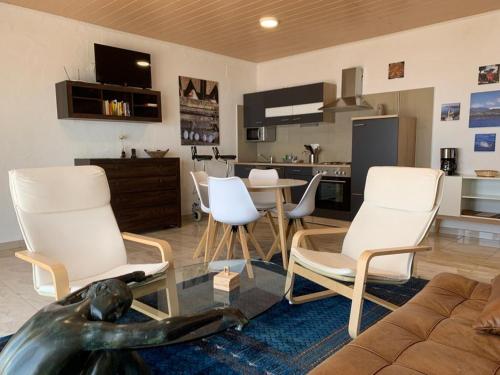 蒂哈拉费HRlos Piratas - Ferien Haus La Palma - GOOD WLAN !!的客厅配有白色的椅子和桌子