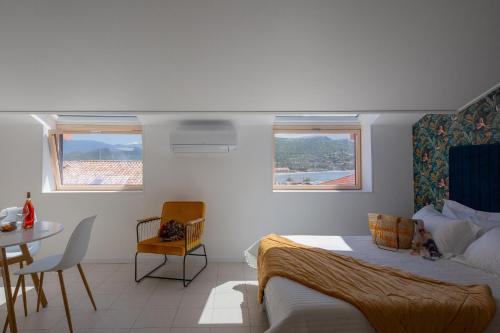 圣弗洛朗Hotel Résidence San Roccu的卧室配有一张床和一张桌子及椅子